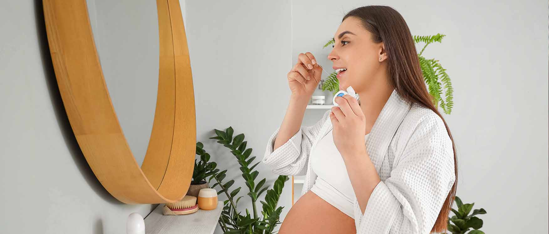 Pregnant woman flossing