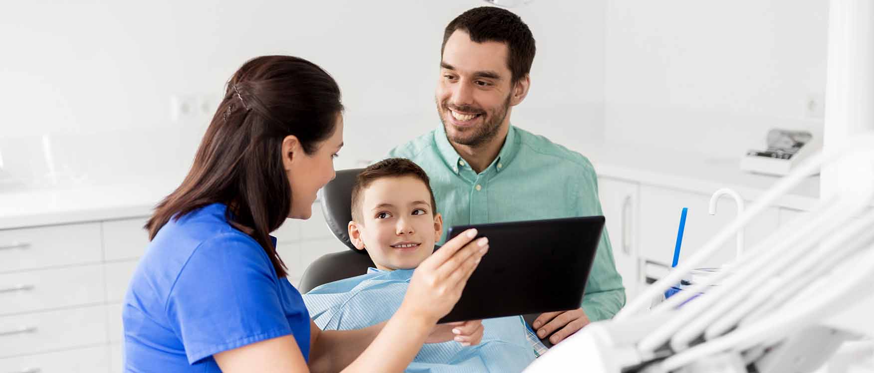 child and father talking to dentist