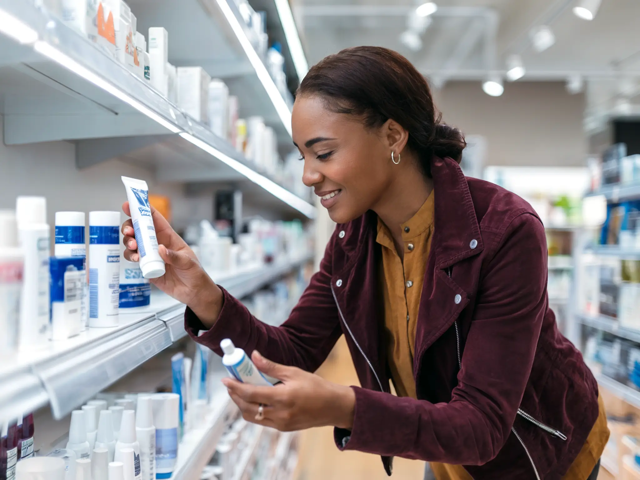Shopper compares oral care products in a store aisle.